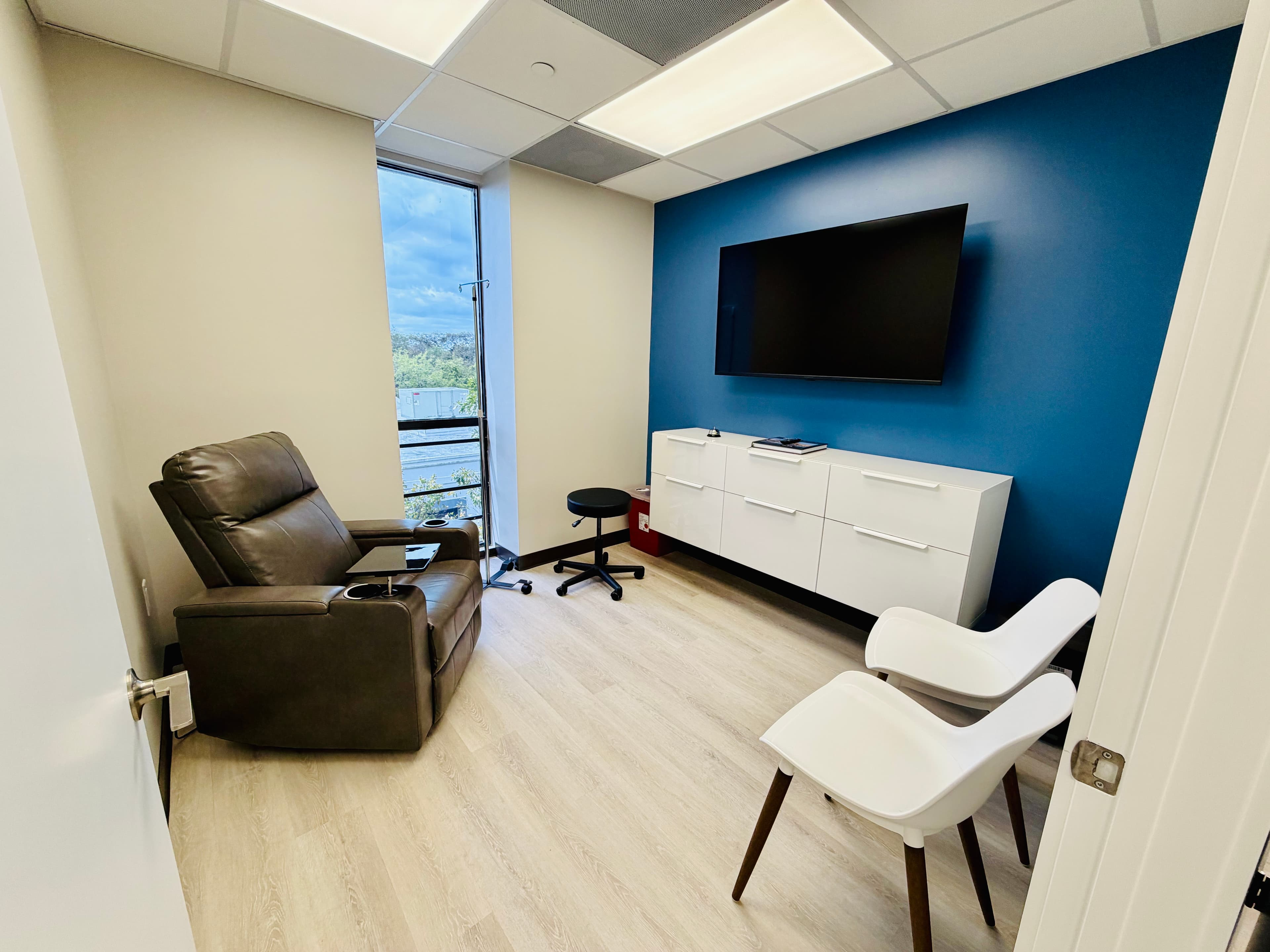 Private infusion treatment suite with comfortable recliner and TV